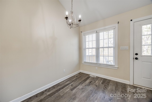 interior space featuring lofted ceiling, dark wood-type flooring, and a chandelier