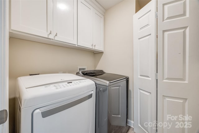 clothes washing area featuring cabinets and independent washer and dryer