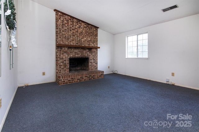 unfurnished living room with lofted ceiling, carpet floors, and a brick fireplace