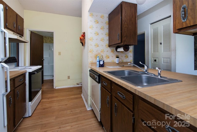 kitchen with electric stove, dishwasher, sink, dark brown cabinets, and light hardwood / wood-style flooring