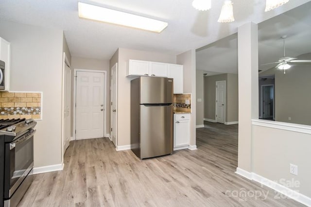 kitchen featuring ceiling fan, appliances with stainless steel finishes, white cabinetry, tasteful backsplash, and light wood-type flooring