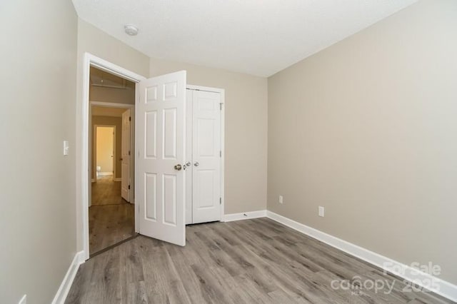 unfurnished bedroom featuring light hardwood / wood-style floors and a closet