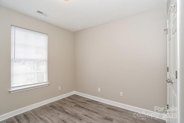 unfurnished room with wood-type flooring