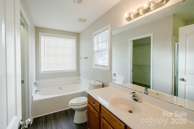 bathroom with wood-type flooring, toilet, a bathing tub, and vanity