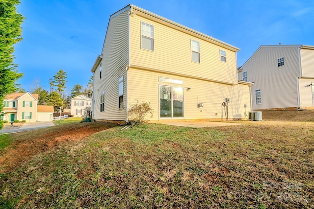 rear view of property with central AC, a patio area, and a lawn