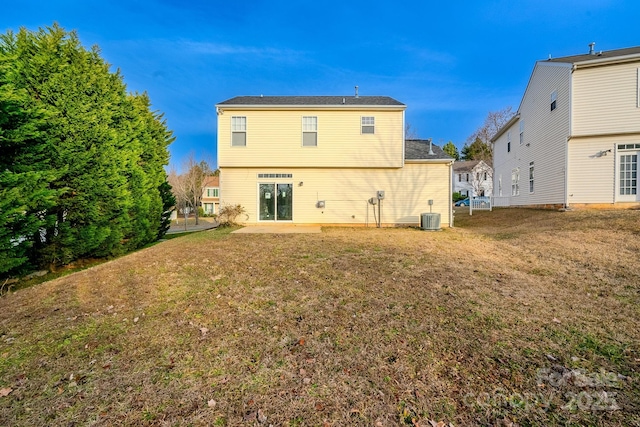 rear view of property with cooling unit, a yard, and a patio