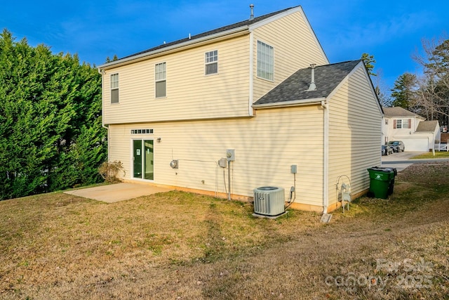 rear view of property with a lawn, a patio, and central air condition unit