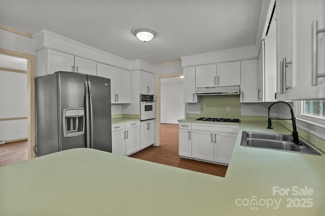 kitchen with sink, white oven, stainless steel refrigerator with ice dispenser, gas stovetop, and white cabinets