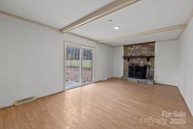 unfurnished living room with beamed ceiling, light wood-type flooring, and a fireplace