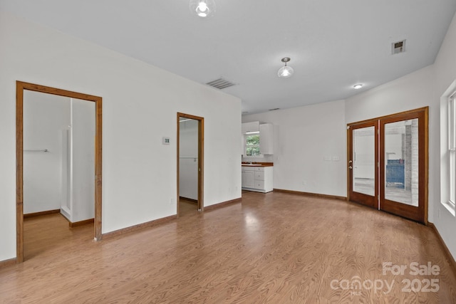 empty room featuring light hardwood / wood-style floors and french doors