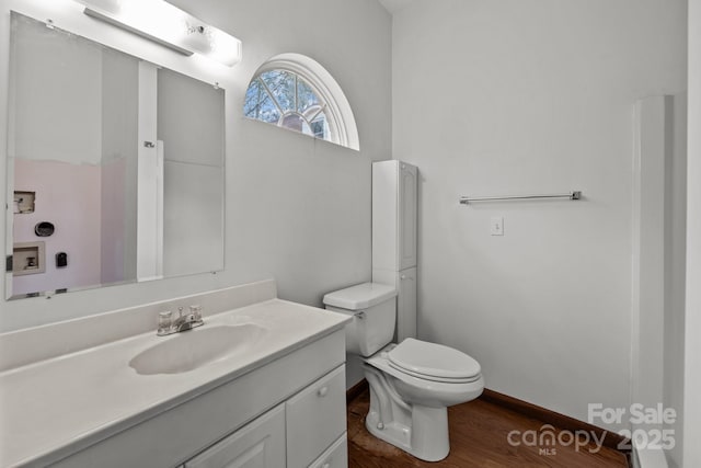 bathroom featuring vanity, wood-type flooring, and toilet