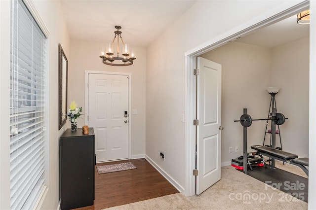 foyer entrance with hardwood / wood-style floors and an inviting chandelier