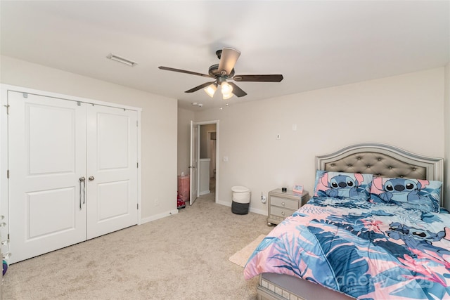 bedroom featuring light colored carpet, a closet, and ceiling fan