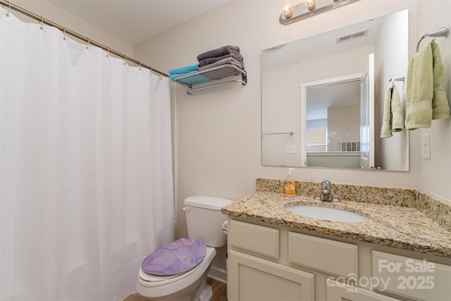 bathroom with vanity, walk in shower, and toilet