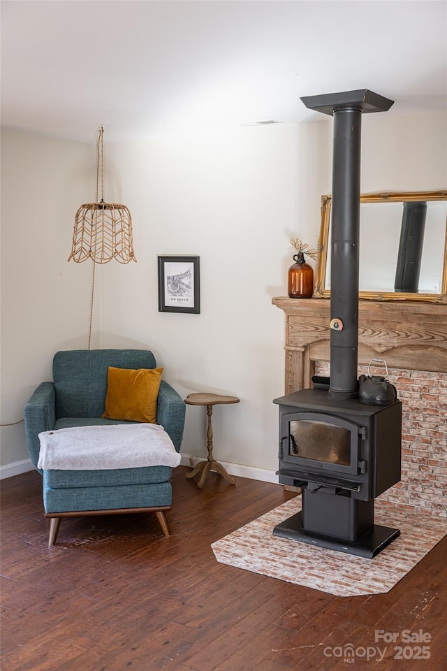 sitting room with dark wood-type flooring and a wood stove