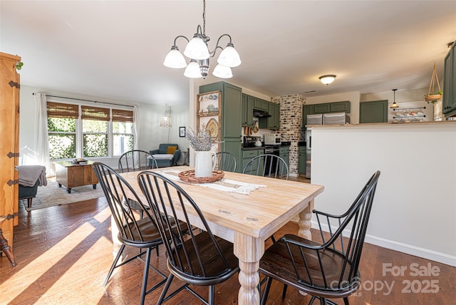 dining space with hardwood / wood-style floors and a chandelier