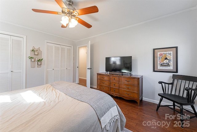 bedroom with multiple closets, ornamental molding, ceiling fan, and dark hardwood / wood-style flooring