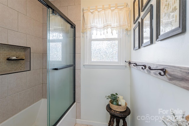 bathroom featuring combined bath / shower with glass door