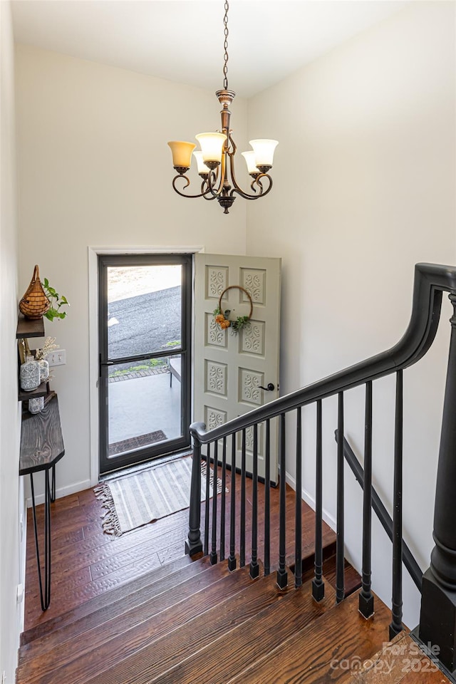 entrance foyer featuring dark hardwood / wood-style floors and a notable chandelier