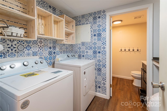 clothes washing area with dark wood-type flooring and independent washer and dryer