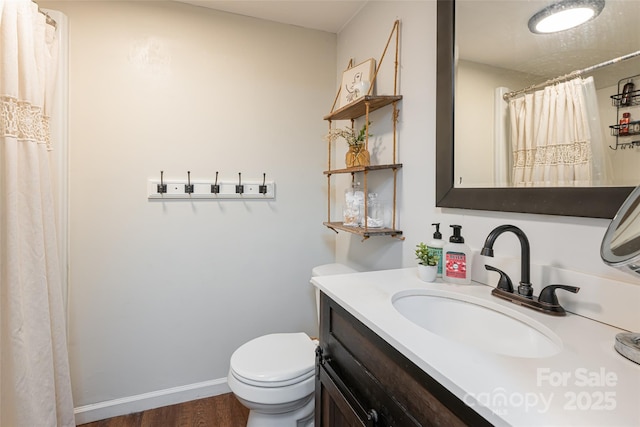 bathroom featuring vanity, toilet, and hardwood / wood-style floors