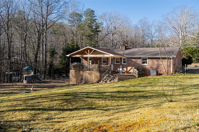 view of front of home with a playground, central air condition unit, and a front lawn