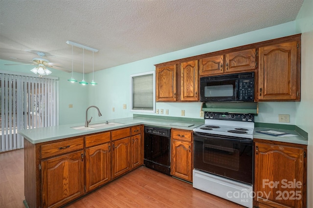 kitchen with sink, a textured ceiling, kitchen peninsula, light hardwood / wood-style floors, and black appliances