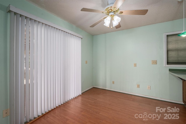 empty room featuring hardwood / wood-style floors, a textured ceiling, and ceiling fan