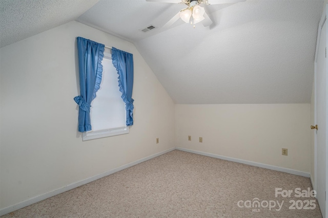 bonus room with ceiling fan, lofted ceiling, carpet floors, and a textured ceiling