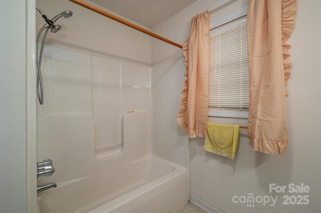 bathroom with shower / bathing tub combination and a textured ceiling