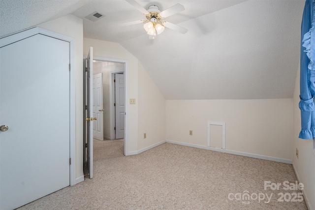 bonus room with light carpet, ceiling fan, lofted ceiling, and a textured ceiling