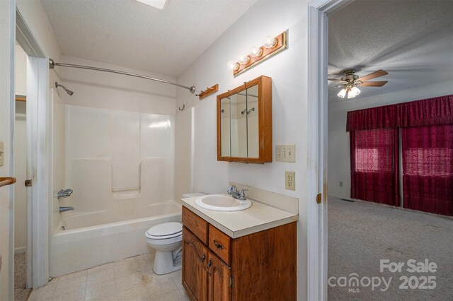 full bathroom featuring washtub / shower combination, vanity, toilet, and a textured ceiling