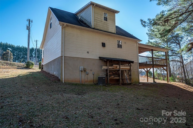 back of property with a wooden deck, a yard, and central air condition unit