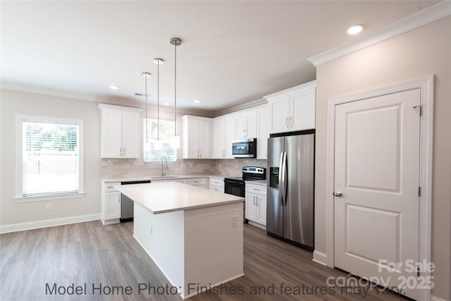 kitchen featuring stainless steel appliances, white cabinetry, a center island, and pendant lighting