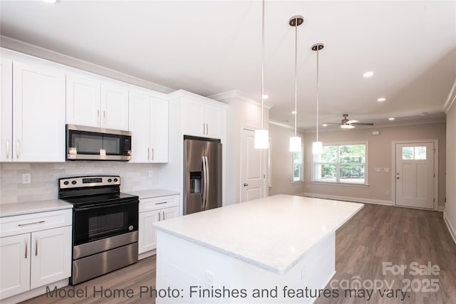 kitchen featuring white cabinetry, tasteful backsplash, decorative light fixtures, a center island, and stainless steel appliances