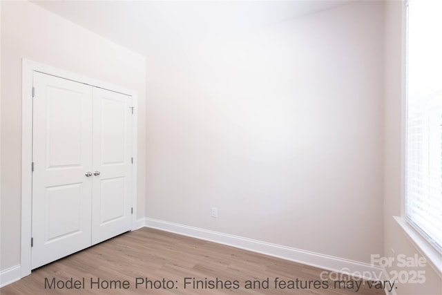 unfurnished bedroom featuring a closet and light wood-type flooring