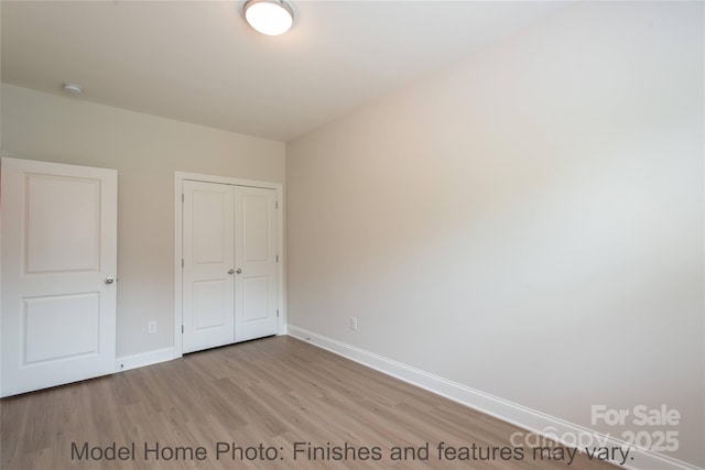 unfurnished bedroom featuring a closet and light wood-type flooring