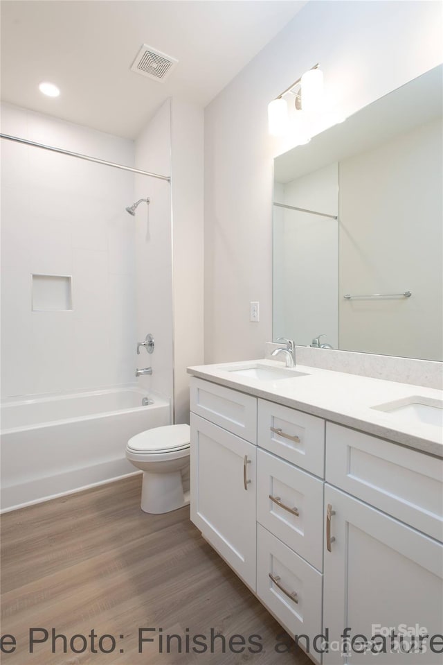 full bathroom with vanity, tub / shower combination, wood-type flooring, and toilet