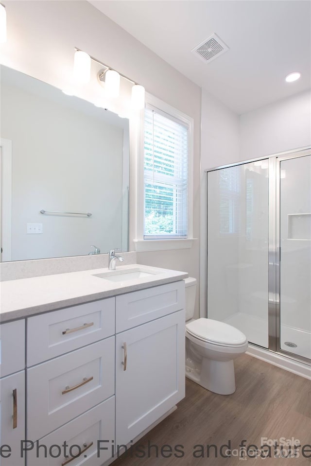 bathroom with vanity, hardwood / wood-style floors, toilet, and walk in shower