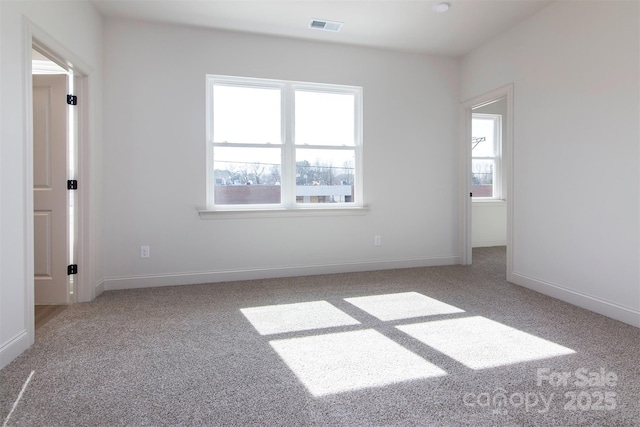 unfurnished room with light colored carpet, visible vents, and baseboards