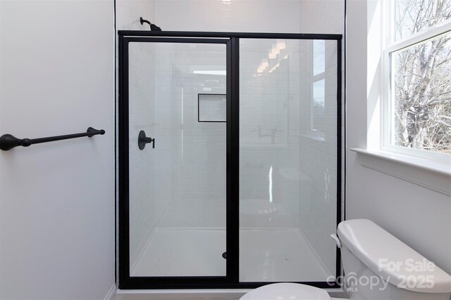 full bathroom with a stall shower and toilet