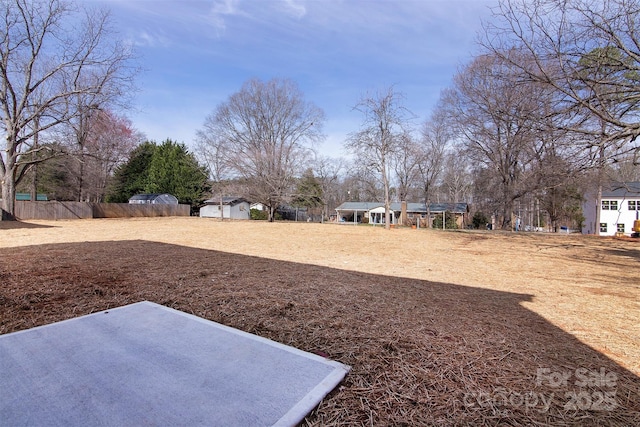 view of yard featuring a shed, fence, and an outdoor structure