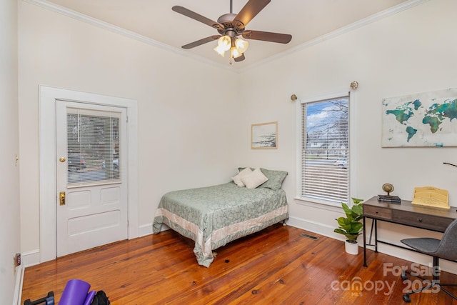 bedroom featuring wood-type flooring, ornamental molding, and ceiling fan