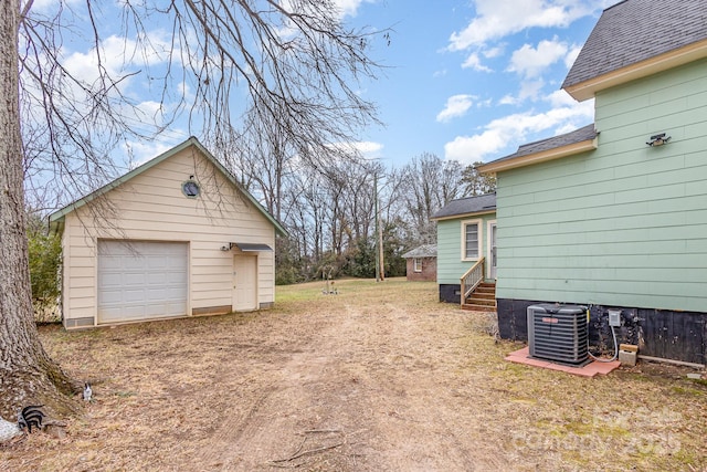 view of yard featuring a garage, an outdoor structure, and central air condition unit