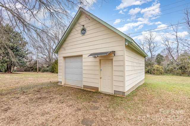 view of outdoor structure with a yard and a garage