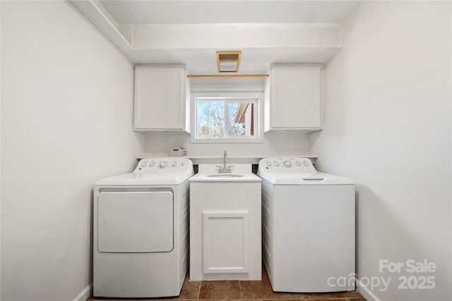 clothes washing area featuring cabinets, sink, and washing machine and clothes dryer