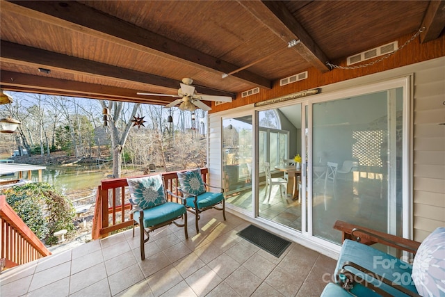 sunroom featuring beam ceiling, ceiling fan, and wood ceiling