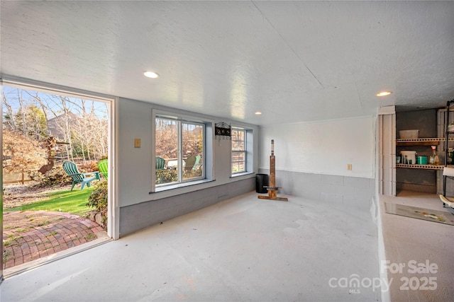 unfurnished living room featuring concrete flooring and a textured ceiling