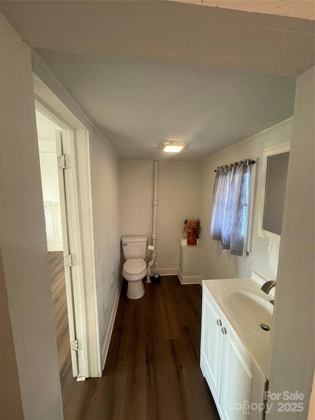 bathroom with vanity, hardwood / wood-style flooring, crown molding, and toilet