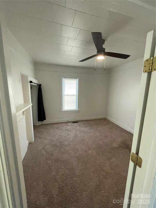 carpeted spare room with ceiling fan